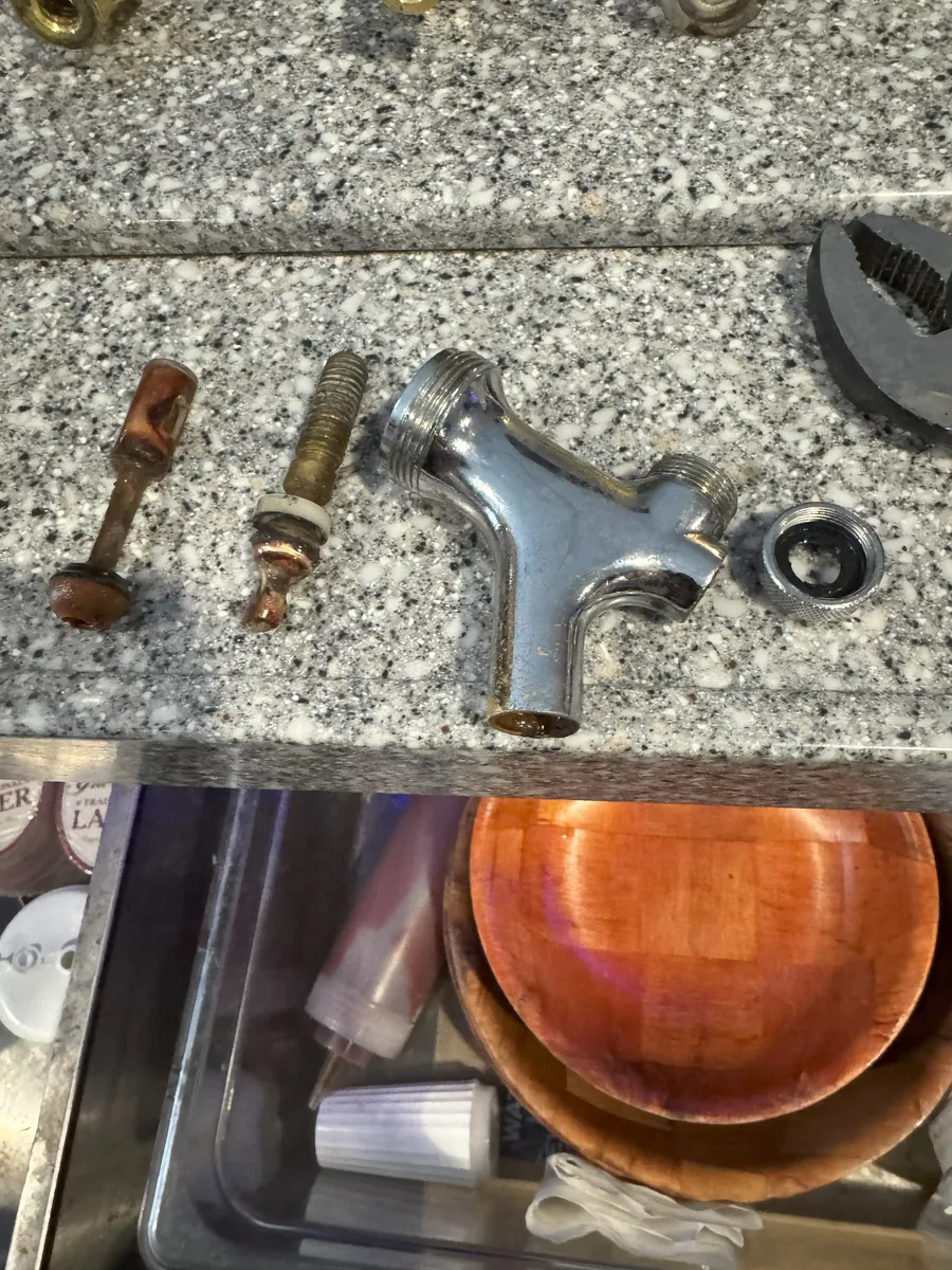 Disassembled beer faucet parts showing visible buildup before cleaning